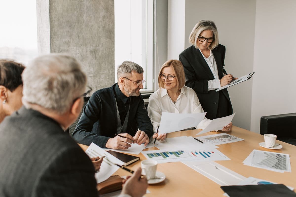 Colleagues reviewing workflow documents together at a table